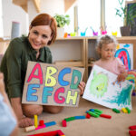Førskolelærer og barn som lærer bokstaver